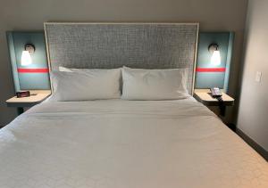 1 cama grande con almohadas blancas y 2 mesitas de noche en avid hotels - Salem, an IHG Hotel en Salem