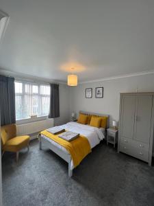 a bedroom with a large bed and a chair at The Homestead House in Doncaster