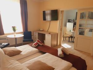 a hotel room with two beds and a television at Pension Celia in Wismar