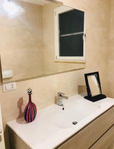 a bathroom with a sink with a vase on it at Villa“La Salentina” in Castrignano del Capo +28 photos