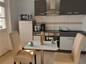 a kitchen with a table and two chairs and a stove at Pension Celia in Wismar