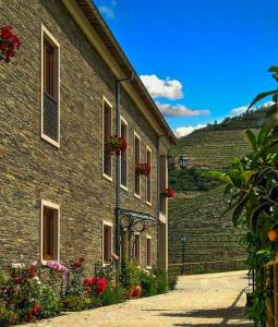 ein Backsteingebäude mit Blumen davor in der Unterkunft Hotel Rural da Quinta do Silval in Pinhão