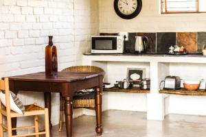a kitchen with a table and a clock on the wall at Gerald's Gift Guest House in Addo