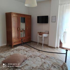 a bedroom with a bed and a cabinet and a desk at Agriturismo La Ca' d'Amelio in Lessolo