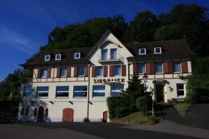 ein großes weißes Gebäude mit einem Schild drauf in der Unterkunft Hotel Restaurant Siegblick in Siegburg