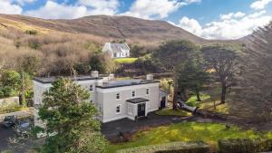 an aerial view of a white house in the hills at The Convent Leenane in Leenaun