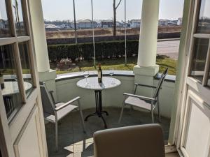 eine Terrasse mit einem Tisch, Stühlen und einem Fenster in der Unterkunft Pension Celia in Wismar