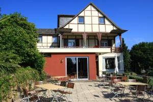 a house with tables and chairs in front of it at Hotel Restaurant Siegblick in Siegburg
