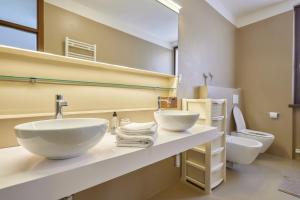 a bathroom with two sinks and a toilet at Lake Front Casa Christina in Malcesine +24 photos