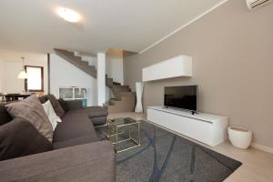 a living room with a couch and a tv at Lake Front Casa Christina in Malcesine