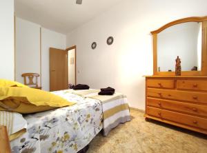 a bedroom with a bed and a dresser and a mirror at Apartamento L 'Altina a 40 metros de la playa in Alcossebre