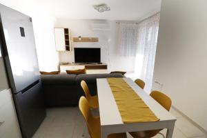 een woonkamer met een tafel en een bank bij Galerius Golden Beach Apartment in Siófok