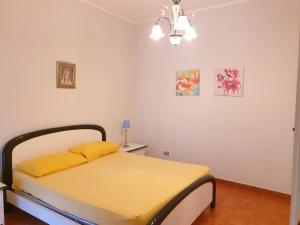 1 dormitorio con 1 cama con sábanas amarillas y lámpara en Residenza armonia, en Gallipoli