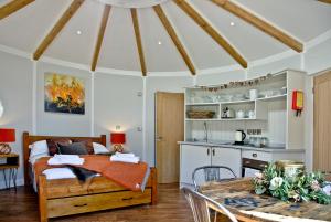 a room with a bed and a table and a kitchen at East Thorne Glamping in Bude