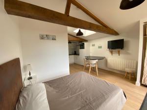 Un dormitorio con una cama y una mesa en una habitación. en Gites de la Marniere, en Mouchamps