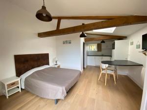 Un dormitorio con una cama, un escritorio y una mesa. en Gites de la Marniere, en Mouchamps
