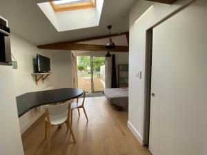 Una habitación con mesa de comedor y un dormitorio. en Gites de la Marniere, en Mouchamps