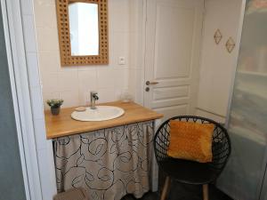 a bathroom with a sink and a chair at Séjour à la campagne in Bouhy
