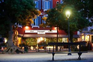カルヴィにあるHotel Restaurant Christophe Colombの通灯付きの建物前のベンチ