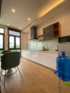 a kitchen with white cabinets and a table and chairs at Vinhomes Imperia in Hai Phong