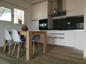 een keuken met een houten tafel en witte kasten bij La casa dei fichi in Porto Azzurro