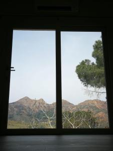 twee ramen in een kamer met uitzicht op de bergen bij La casa dei fichi in Porto Azzurro