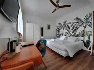Schlafzimmer mit einem Bett und einem Schreibtisch mit einem Laptop in der Unterkunft Hôtel Le Saint Pierre, La Baule-Escoublac in La Baule