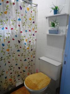 a bathroom with a toilet and a shower curtain with butterflies at Casa com Piscina Paraty in Paraty