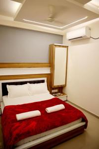 a bedroom with a bed with two towels on it at Hotel Sai Maa in Shirdi