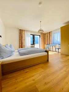 a bedroom with a large bed with a wooden floor at Haus Alpenrose in Trins