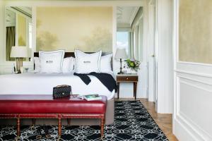 una camera con un grande letto e una panca rossa di BLESS Hotel Madrid - The Leading Hotels of the World a Madrid