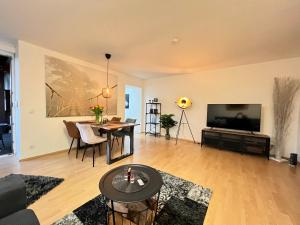 a living room with a flat screen tv and a table at Wohnen im alten Amtsgericht im Herzen von Xanten in Xanten