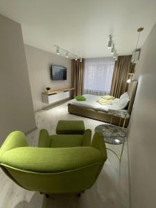 1 dormitorio con sofá verde y cama en “Same as Home apt”M.Zhusupa str. 284/1, en Pavlodar