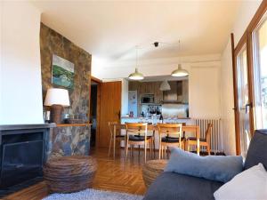 a living room and kitchen with a couch and a table at Apartamento en Llívia ideal 8 personas con piscina in Llivia