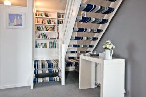 a room with a staircase with bookshelves at Spindrift in Praa Sands