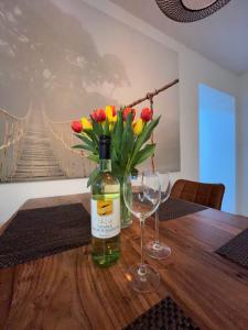 a bottle of wine and two glasses on a table with flowers at Wohnen im alten Amtsgericht im Herzen von Xanten in Xanten +29 photos