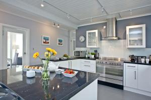 a kitchen with a table with a vase of flowers at Spindrift in Praa Sands