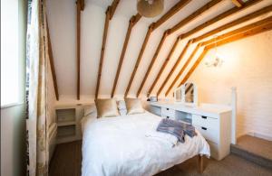a bedroom with a bed and a desk in a room at Dreamy Suffolk Country Cottage Escape in Aldeby