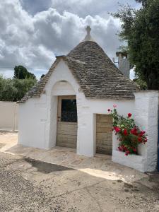 a small white building with a garage with a window at Trullidea in Alberobello