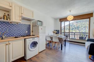 a kitchen with a washing machine and a dining room at Le Gentiana in Saint-Nicolas-la-Chapelle