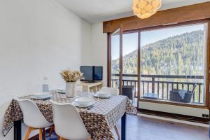 a dining room with a table and chairs and a large window at Le Gentiana in Saint-Nicolas-la-Chapelle +8 photos