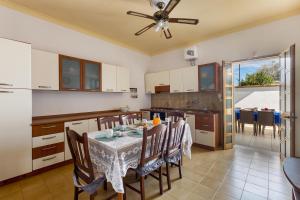 a kitchen and dining room with a table and chairs at Villa Rosa di Mare by BararHouse in Torre Lapillo +24 photos
