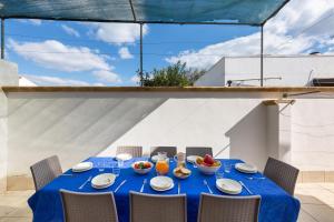 a blue table with chairs and a blue table umbrella at Villa Rosa di Mare by BararHouse in Torre Lapillo