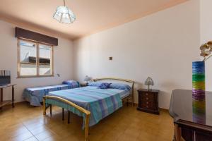 a bedroom with two beds and a tv and a window at Villa Rosa di Mare by BararHouse in Torre Lapillo