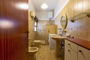 a bathroom with a toilet and a sink and a mirror at Villa Rosa di Mare by BararHouse in Torre Lapillo