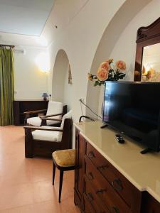 uma sala de estar com uma televisão de ecrã plano e um sofá em Casa Vacanze Fattoria Pozzitello em San Salvo