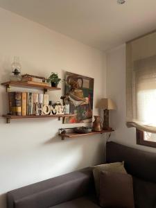 sala de estar con sofá y estanterías en la pared en La casa de las Flores de El Hornillo, en El Hornillo