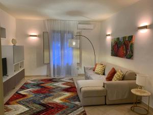 un soggiorno con divano e un grande tappeto di Terre dAci Apartments - casa Vastea ad Acireale