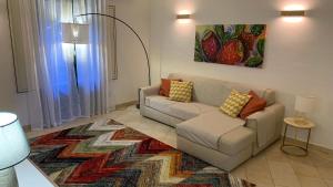 un soggiorno con divano e tappeto di Terre dAci Apartments - casa Vastea ad Acireale
