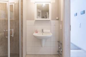 La salle de bains est pourvue d'un lavabo et d'un miroir. dans l'établissement Altstadtstübchen, à Husum